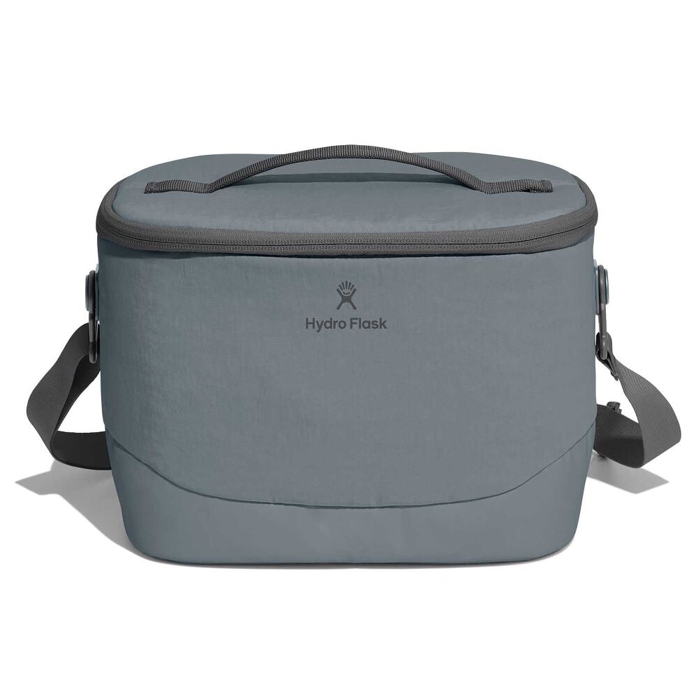 Open gray Hydro Flask insulated lunch bag packed with fruit container, apple, green food jar, blue case, soda can, and small items. Soft interior lining with zipper.